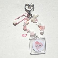 a keychain with a heart and cross charms attached to it's side