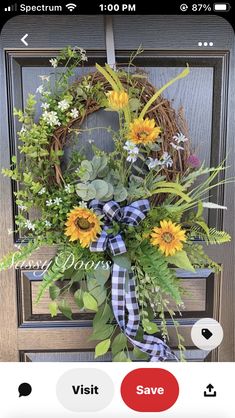 a wreath with sunflowers and greenery on the front door