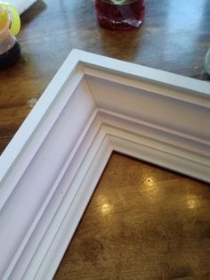 a white frame sitting on top of a wooden table