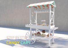 a white cart with cupcakes under a striped awning