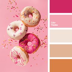 three donuts with sprinkles are on a pink and orange color palette