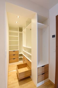 an empty walk in closet with white walls and wood flooring on the other side