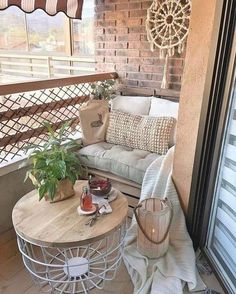 a balcony with a couch, table and potted plant