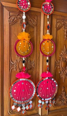 two red and yellow ornaments hanging from a wooden door