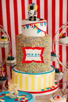 a circus themed birthday cake with sprinkles and decorations on the top tier