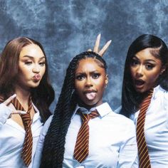 three young women dressed in school uniforms posing for the camera with their mouths open and tongue out