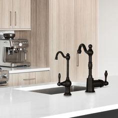 two faucets on the kitchen counter in front of an espresso machine