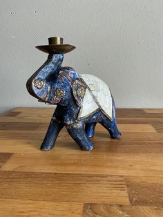 an elephant figurine with a hat on it's head sitting on a wooden table