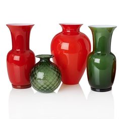 four different colored vases sitting next to each other