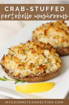 two stuffed mushrooms on a plate with lemon wedges