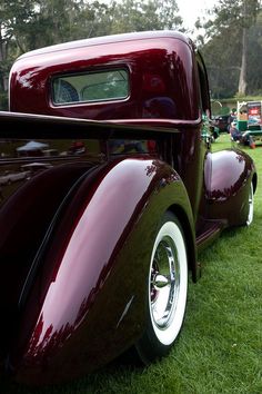 an antique car is parked on the grass