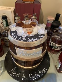 a birthday cake made to look like a barrel with liquor bottles in the back and on top