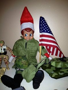 a toy soldier sitting on top of a counter next to two american flags and toys