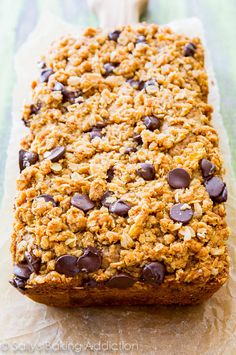 a loaf of chocolate chip oatmeal bread sitting on top of a piece of parchment paper