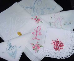 six embroidered handkerchiefs with monogrammed letters and flowers on them, all in different colors