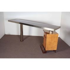 a metal and wood table with drawers on it's sides in an empty room