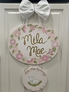 a door hanger that says, mia mae and has a bow on it