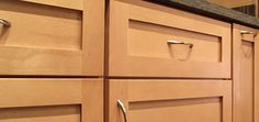 a kitchen with wooden cabinets and stainless steel handles