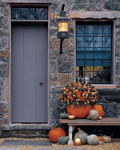 pumpkins and gourds are sitting on the steps in front of a stone building