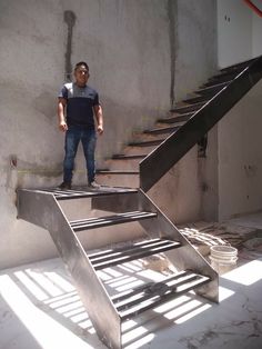 a man standing on top of a metal stair case