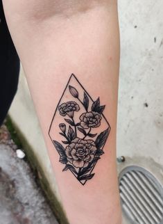 a black and white flower tattoo on the left leg, with an image of roses in a diamond