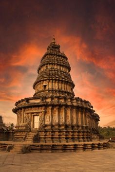 the sun is setting over an old stone structure with carvings on it's sides