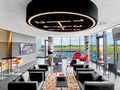 a modern living room with black furniture and large windows looking out onto the water in the distance