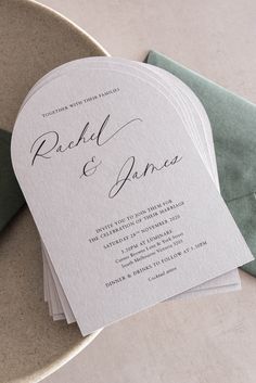 the wedding stationery is laid out on top of an envelope, which sits next to a green napkin