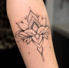 a black and white photo of a tattoo on the arm that has a flower in it