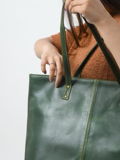 This Kim Tote is a stylish women's tote handbag that is a great choice for a trendy look. The simple, classic design in green makes it superior. The zipper gives easy access to the main compartment, which has one small zipper pocket inside the compartment for keeping your accessories and other small items securely and separately. This women's leather tote bag is made of the finest quality buffalo leather, accentuated with intricate detailing on the stitches. We offer excellent craftsmanship to e Green Shoulder Bag For Shopping, Green Shoulder Bag With Zipper For Daily Use, Green Bag With Zipper For Daily Use, Green Bag With Zipper Closure For Daily Use, Green Everyday Bag With Zipper Closure, Classic Shopping Bag With Zipper Pocket, Green Everyday Satchel With Zipper Pocket, Everyday Green Satchel With Zipper Pocket, Classic Shopping Bags With Zipper Pocket