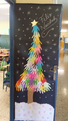 a classroom door decorated with handprints and a christmas tree on the front side