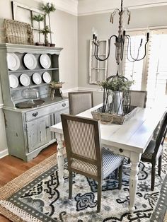 a dining room table with chairs and plates on it in front of a china cabinet