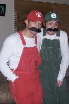 two men with fake moustaches and mustaches on their heads are posing for the camera