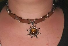 [Click ❤ to get 15% OFF coupon code by Email / Receiving an email from seller should be turned ON] Description: This beautifully crafted Tiger Eye Sun Pendant Necklace is designed with high-quality brown leather, stainless steel, and a genuine natural tiger eye stone. Perfect for those with sensitive skin, this hypoallergenic leather choker is anti-fade and comfortable for everyday wear. Craftsmanship: The necklace features a real tiger eye gemstone with golden-brown hues, adding a bohemian touc Real Tiger, Boho Goth, Grunge Jewelry, Sun Pendant, Golden Jewelry, Tigers Eye Gemstone, Leather Chokers, Goth Grunge, Tiger Eye Stone