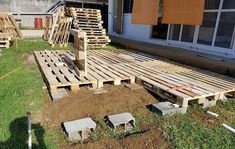 some wooden pallets are laying on the ground in front of a building with windows