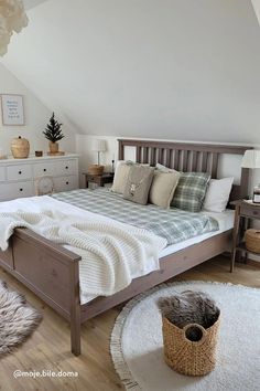 a bedroom with a bed, dressers and rug on the floor in front of it