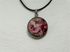 Why not treat yourself or a friend to this one-of-a-kind, wearable art, magenta, pink, white floral abstract pendant necklace. The design looks like a flower garden.  Perfect gift for Valentine's Day, birthdays, Mother's Day, anniversary, bridesmaid's gifts, teacher appreciation gift, BFFs, Bat Mitzvah or "just because".  Materials The pendant's design is made from acrylic pour paint and comes with a high-quality 24 inch black cotton waxed cord necklace with a metal clasp and extension chain (nickel-free).  The necklace comes with a sheer organza mesh jewelry bag with drawstring for gift giving and safe keeping. The round transparent glass cabochon is backed by a lightweight stainless steel tray and measures 25mm / 1 inch in diameter.  Photos were taken with a cell phone. The colors that y Pink Adjustable Flower Pendant Necklace, Hand Painted Pink Flower Jewelry, Pink Hand Painted Flower Jewelry, Artistic Pink Flower Jewelry, Pink Wearable Art Jewelry As Gift, Pink Wearable Art Jewelry For Gift, Handmade Pink Wearable Art Jewelry, Artistic White Round Necklace, Artistic White Necklace For Gift