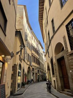 an alleyway with several buildings and motorcycles parked on the side