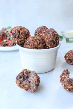 some food is in a white bowl and on the table next to it are three cookies