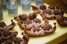 chocolate cupcakes are arranged on trays with flowers in the middle and blue water behind them