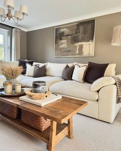 a living room with couches, coffee table and large painting on the wall behind it