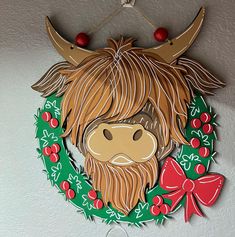 a paper cut out of a cow with a wreath around it's neck hanging on a wall