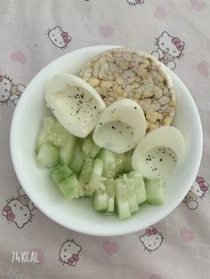 a white bowl filled with sliced up food on top of a hello kitty table cloth