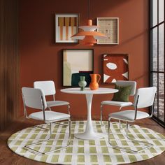 a white table and chairs in a room with an orange color scheme on the wall