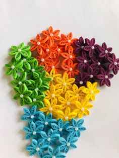 four different colors of hair clips with pearls on the ends and flowers in the middle