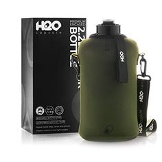 an olive green flask bottle next to a black box