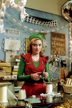 a woman standing in front of a counter holding a cup