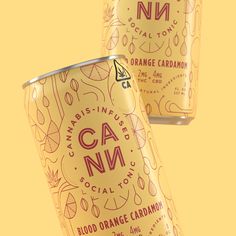 two cans of orange cardamoo on a yellow background