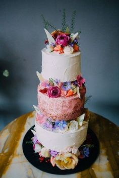 a three tiered cake with flowers on top