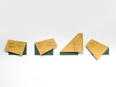 four pieces of yellow paper sitting on top of each other in front of a white background